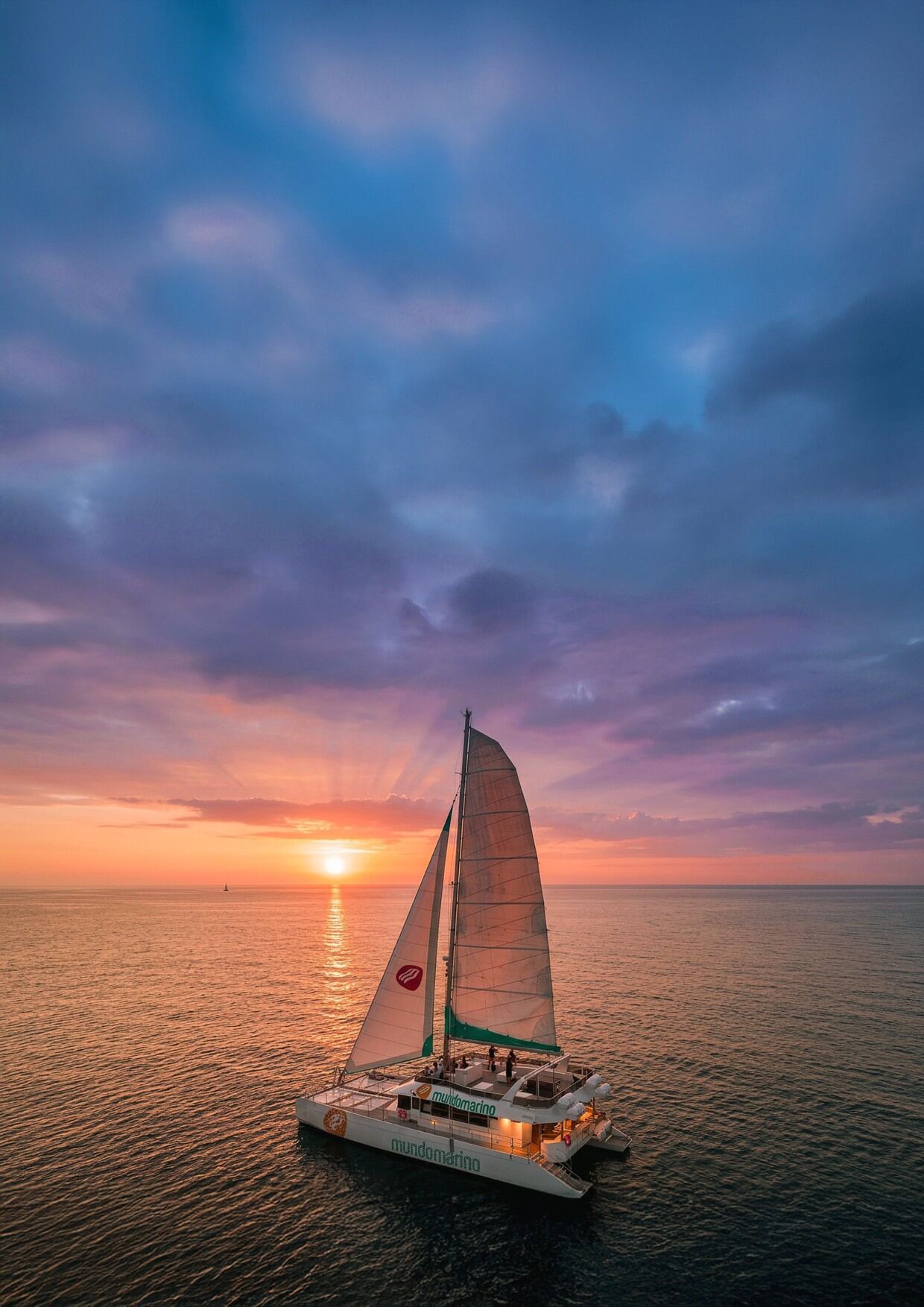 Catamarán Mundo Marino navegando al atardecer